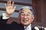 Japan's Emperor Akihito waves to well-wishers from a bullet-proofed balcony of the Imperial Palace in Tokyo.