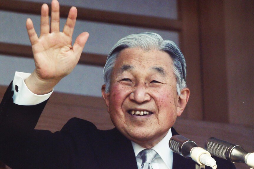 Japan's Emperor Akihito waves to well-wishers from a bullet-proofed balcony of the Imperial Palace in Tokyo.