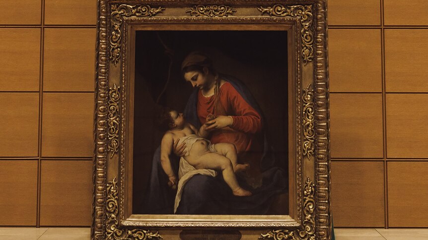 a gold framed painting of a woman and a plump baby . 
