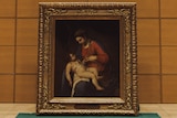 a gold framed painting of a woman and a plump baby . 