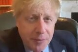 boris johnson in a suit looking at the camera