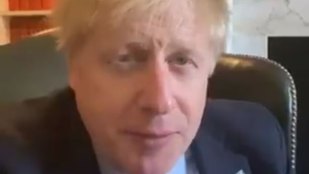 boris johnson in a suit looking at the camera