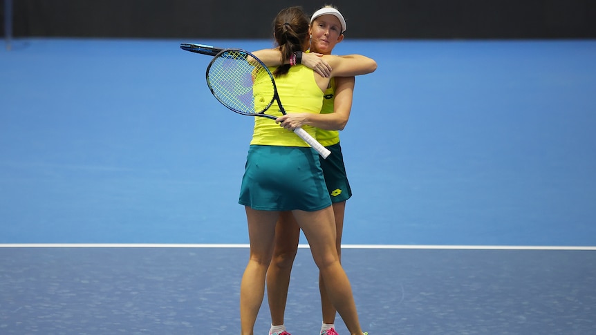 Two Australian players embrace after winning their doubles rubber at the Billie Jean King Cup.