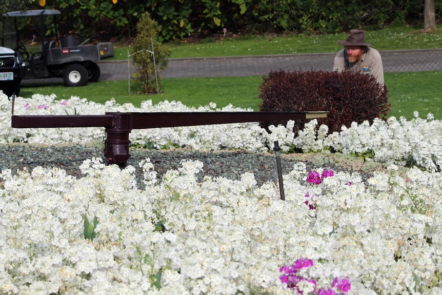 Ken Littler adjusts a floral clock