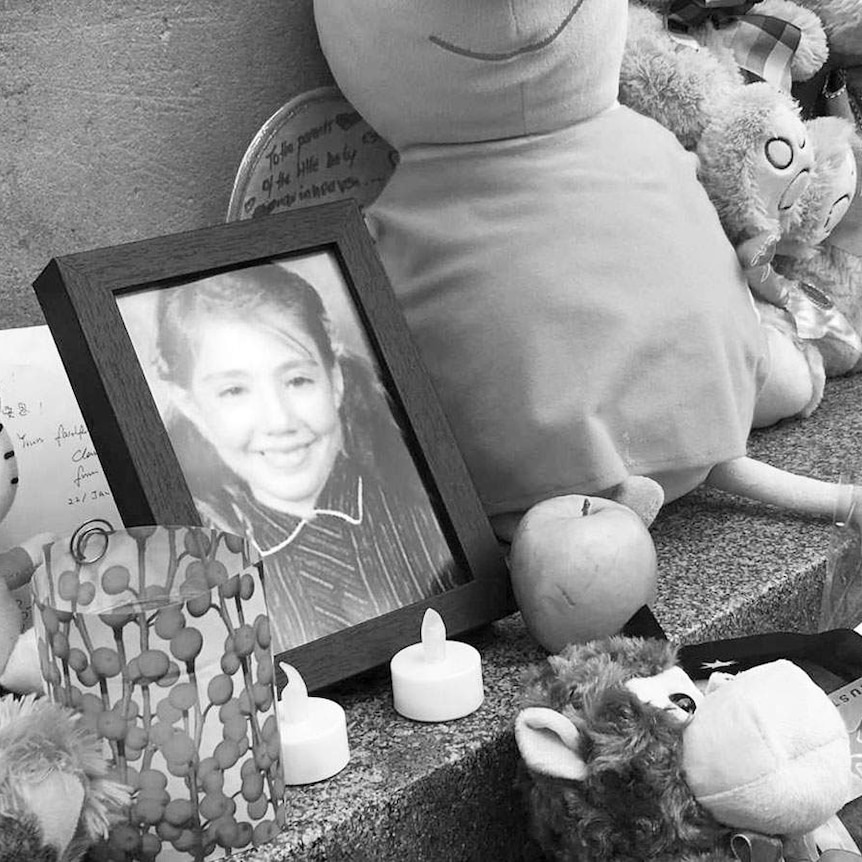A photo of Thalia Hakin at a memorial where there are also candles and toys.