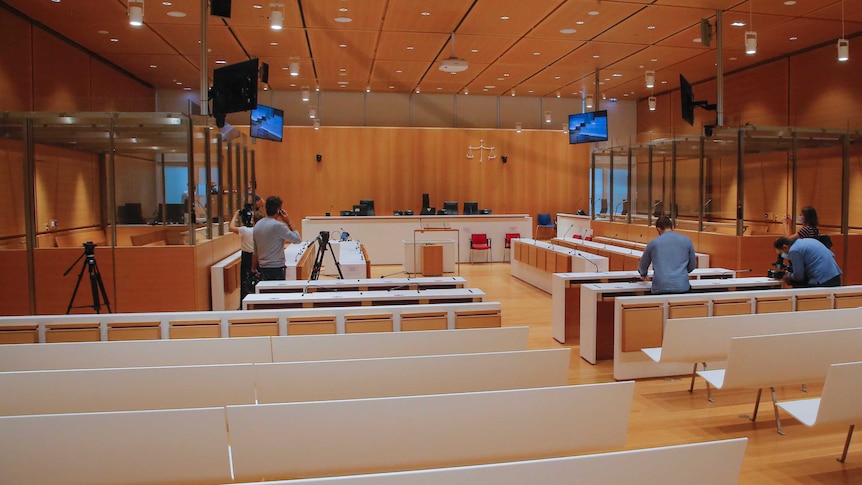 Members of the media walk in the courtroom where the trial of the Charlie Hebdo shooting will take place.