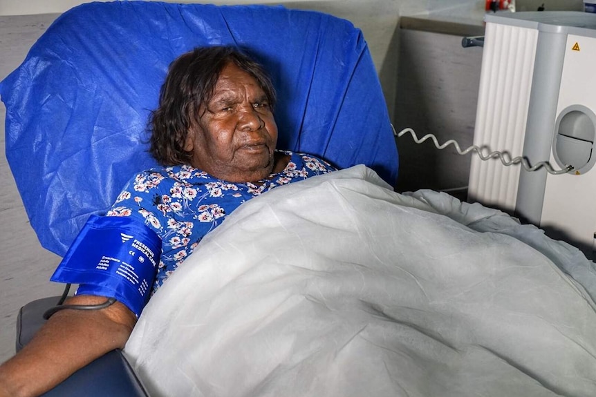 A woman lies in a hospital bed.