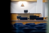 A well-lit courtroom viewed through a doorway. 