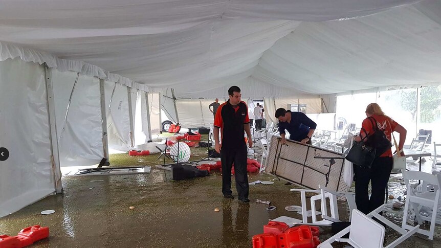 Staff members begin to reassmble tables and pick up debris.