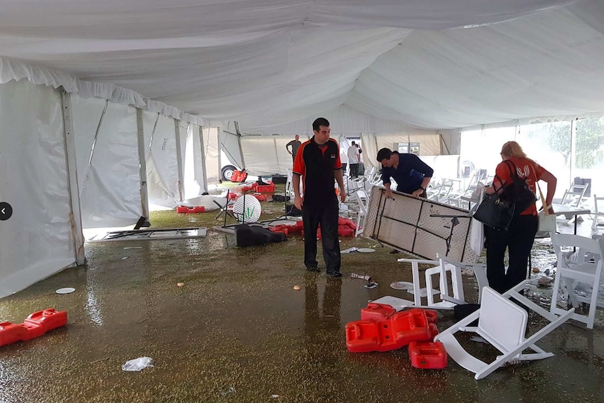 Staff members begin to reassmble tables and pick up debris.