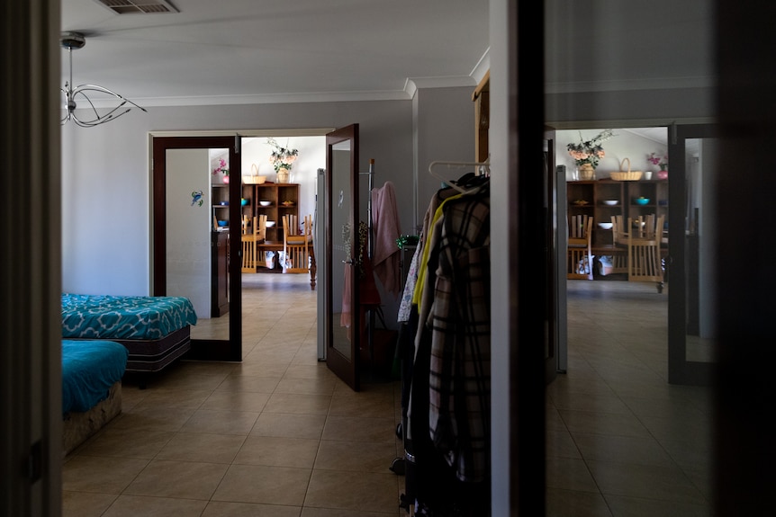 A house crowded with beds and clothes in hallways.