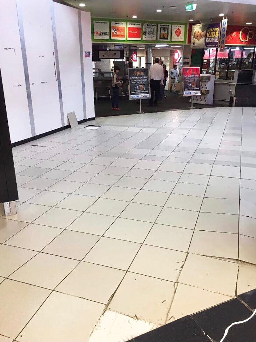 Tiles lifted and buckled on a damaged West End shopping centre floor