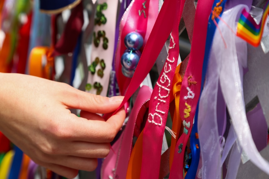 A ribbon with the name Bridget embroidered is visible on the remembering rainbow memorial