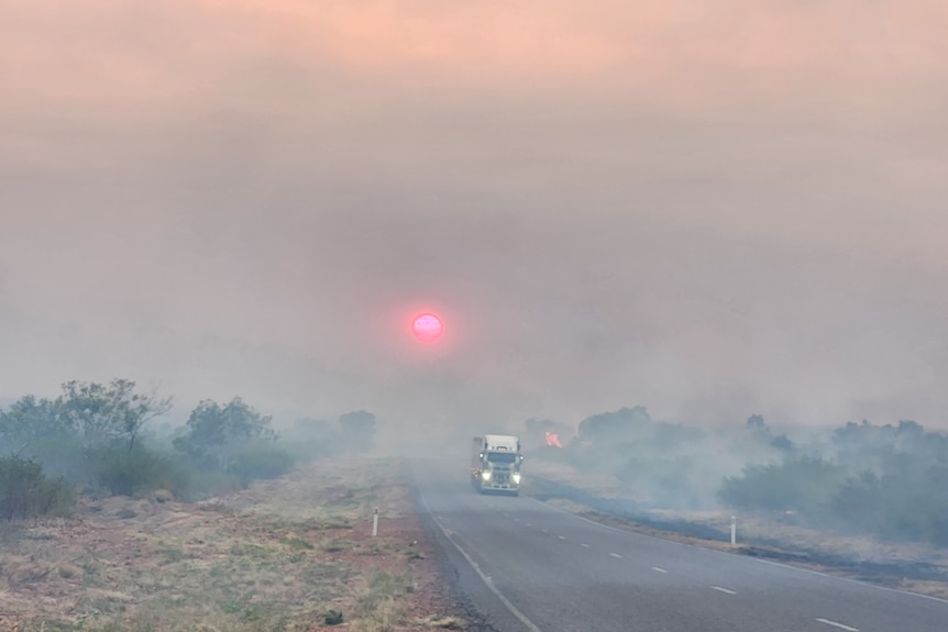 a truck on a highway covered in smoke