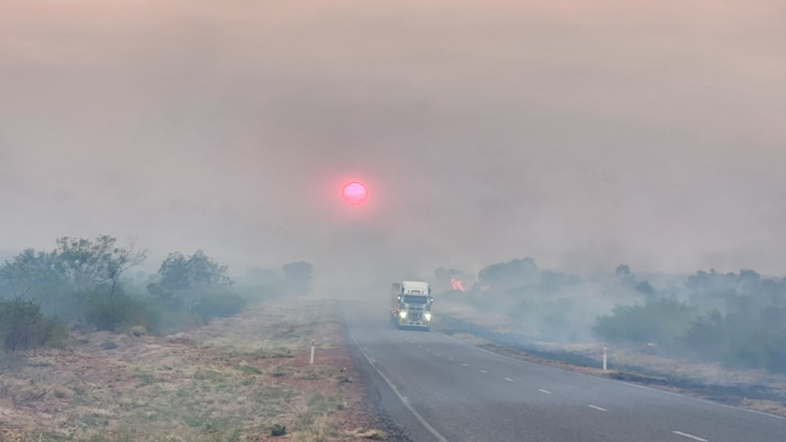 a truck on a highway covered in smoke