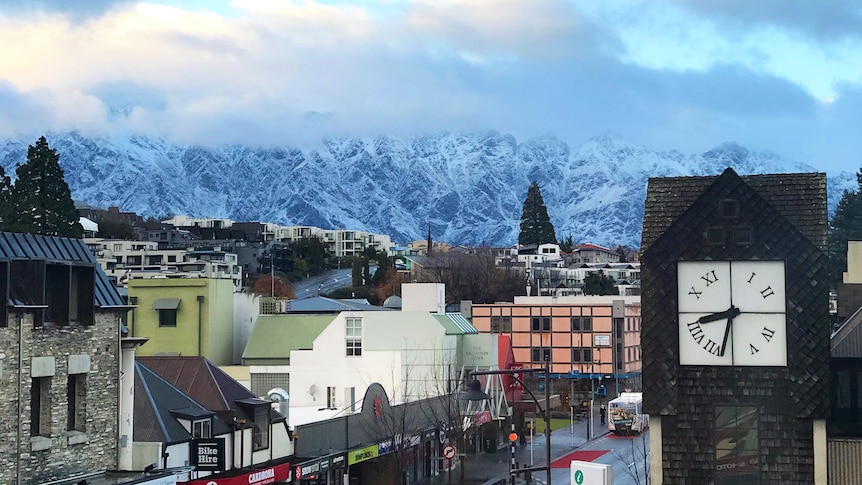 A cityscape with a large mountain range in the distance