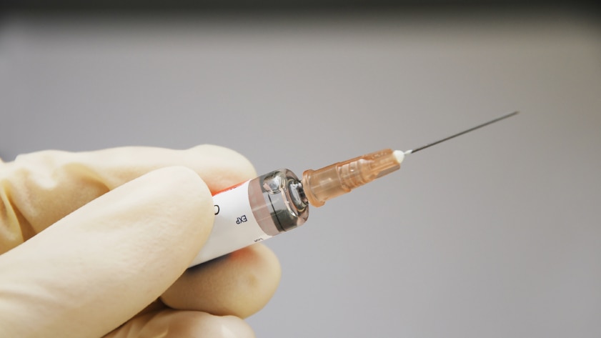 A health worker holding a syringe.