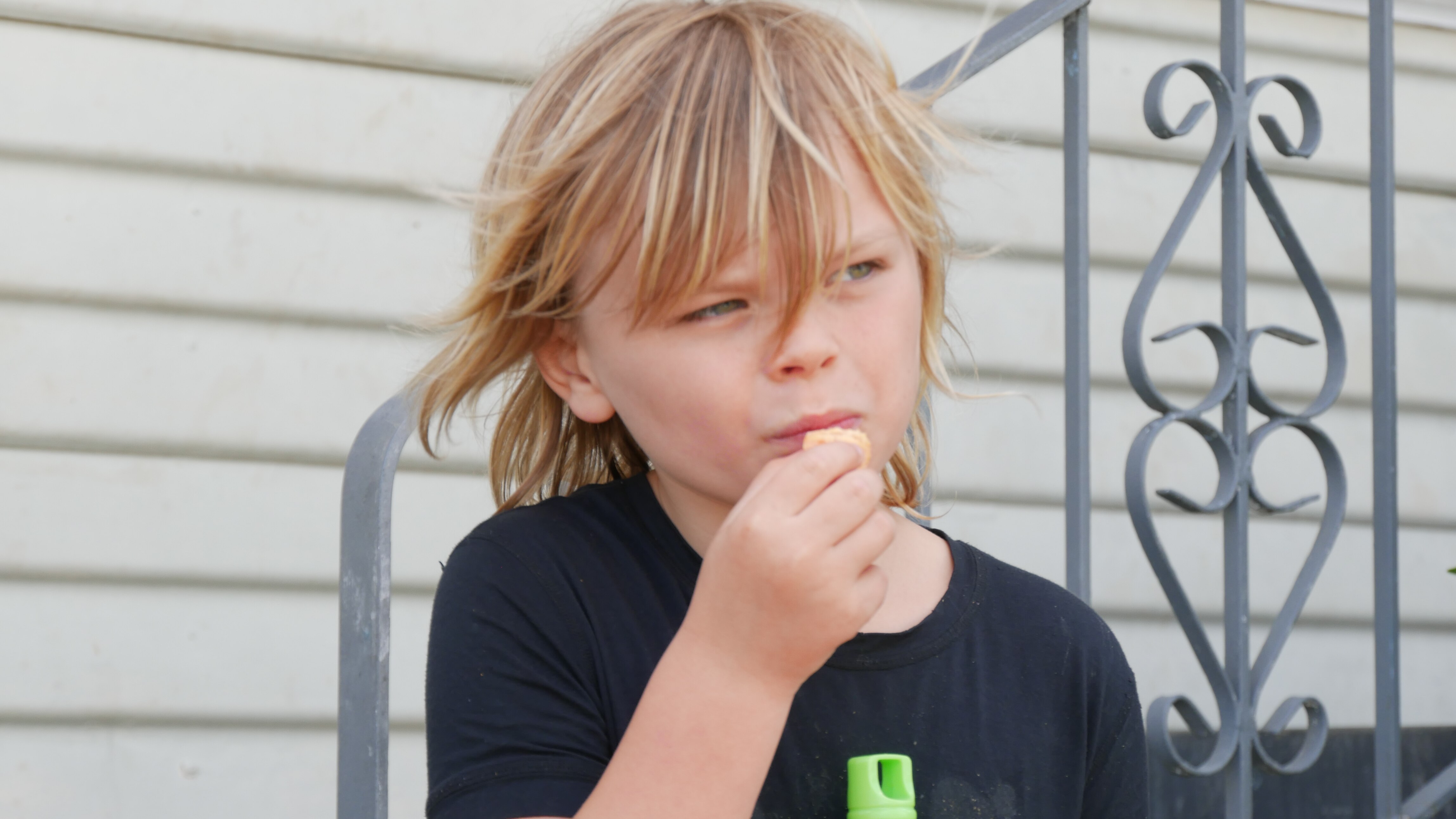 A young boy with blonde hair eats.