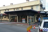 Piolice tape, an officer and a police car guard the Premier Hotel in Albany as a fire hose lays on the ground.