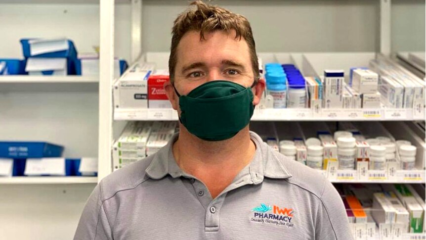 A man wearing a mask in a chemist.