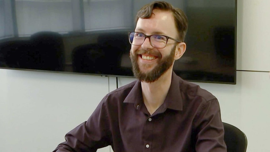 Man sitting at a desk smiling