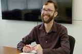 Man sitting at a desk smiling