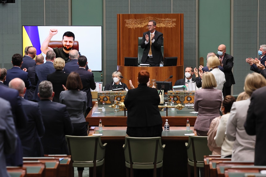 The parliament stands in ovation for an onscreen, fist-pumping Zelenskyy