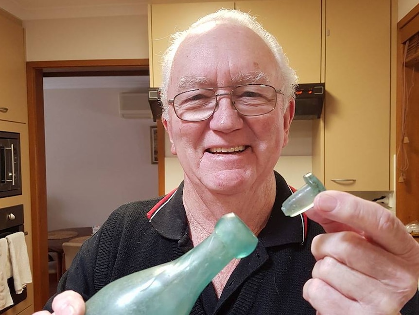 Roy Lawford poses for a photo while he puts the lid on the bottle