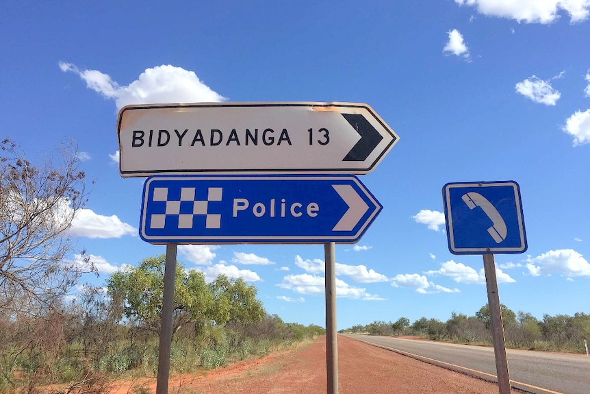 road signs - one with police and the other with Bidyadanga written on them, at roadside