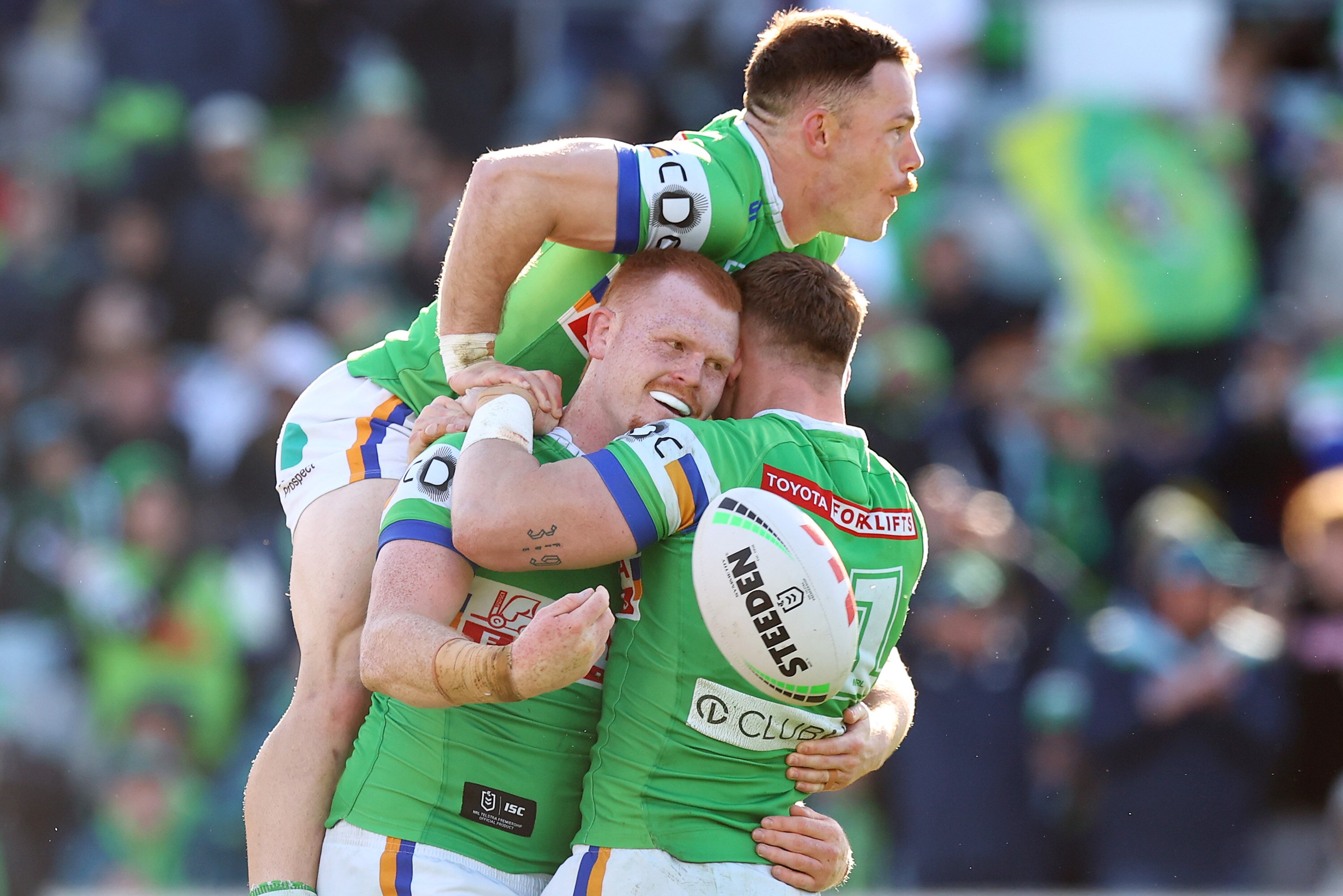Tom Starling jumps on Corey Horsburgh, who is hugging Hudson Young after scoring an NRL try.