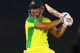 Marcus Stoinis completes a cut shot wearing the bright yellow of Australia