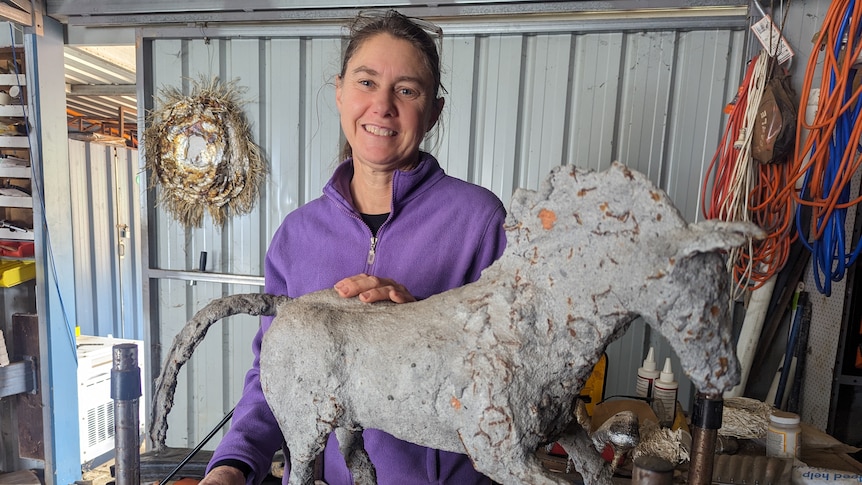 A smiling Heather Barrett with a great sculpture of a horse 