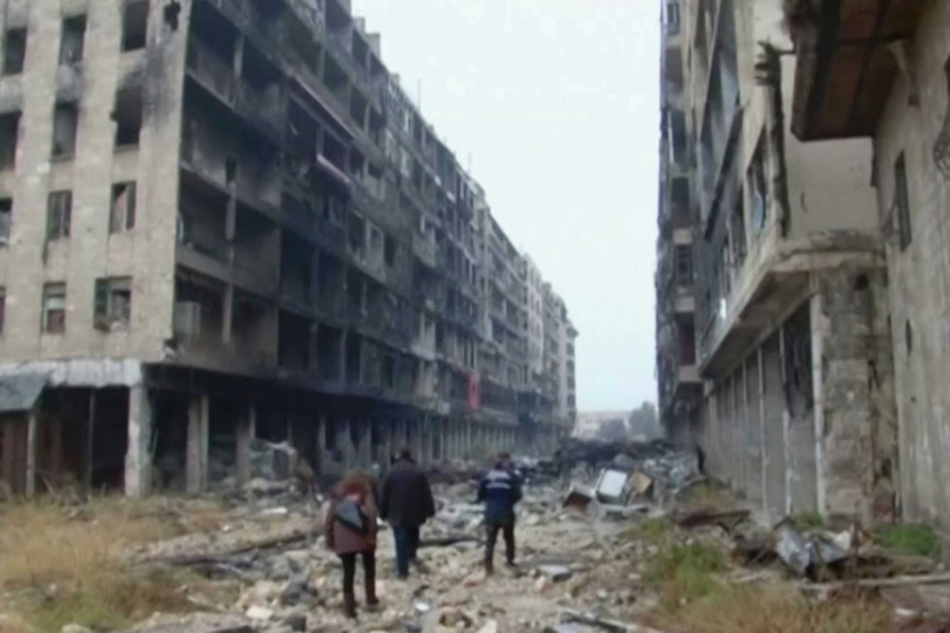 People walk among rubble in Aleppo