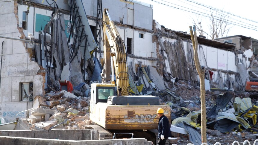 A bulldozer destroys a building at Xinjian village in Beijing's south. 