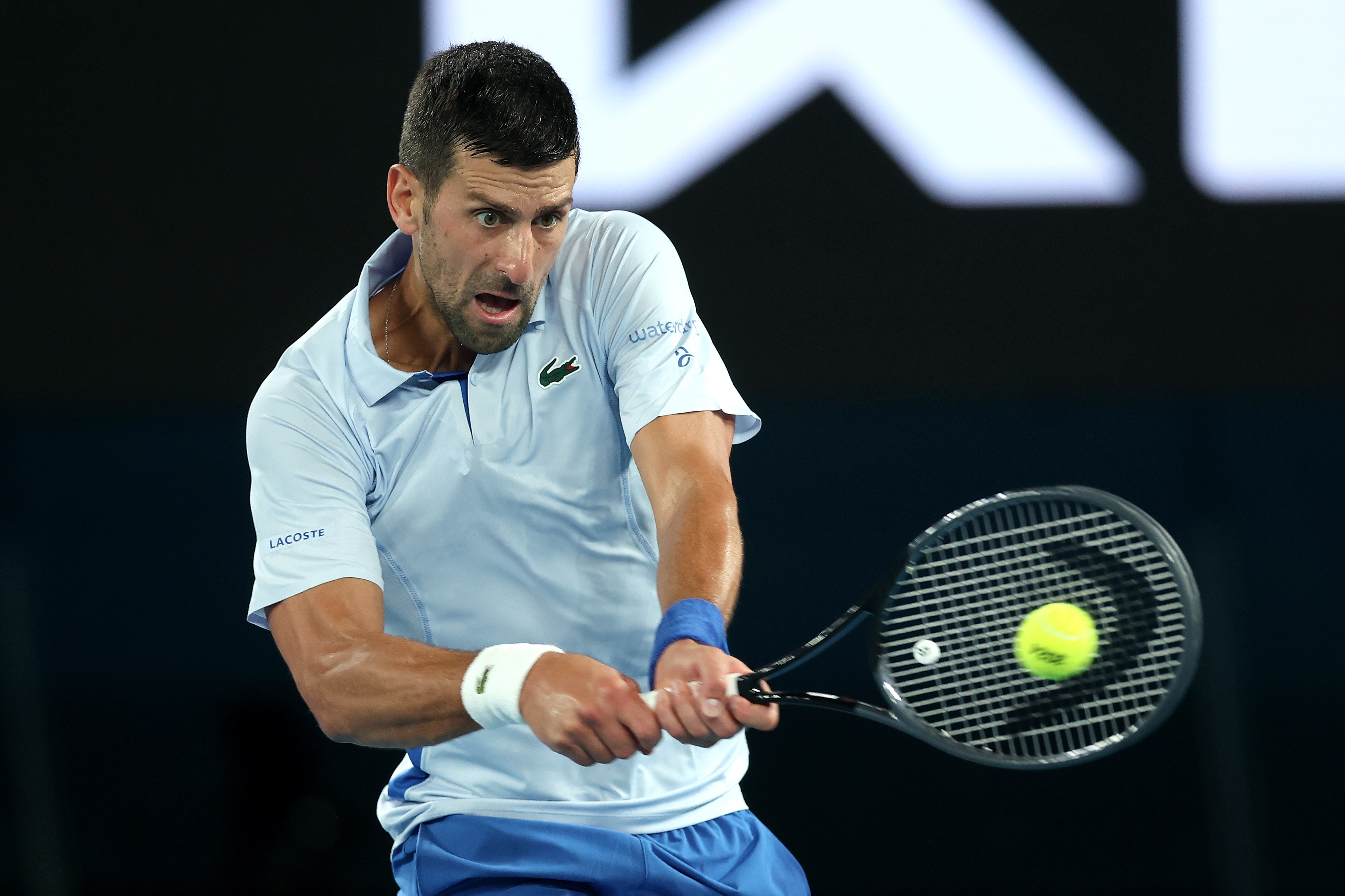 Novak Djokovic plays a backhand at the 2024 Australian Open.
