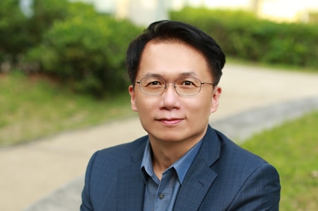 A man in suit sitting beside lawn