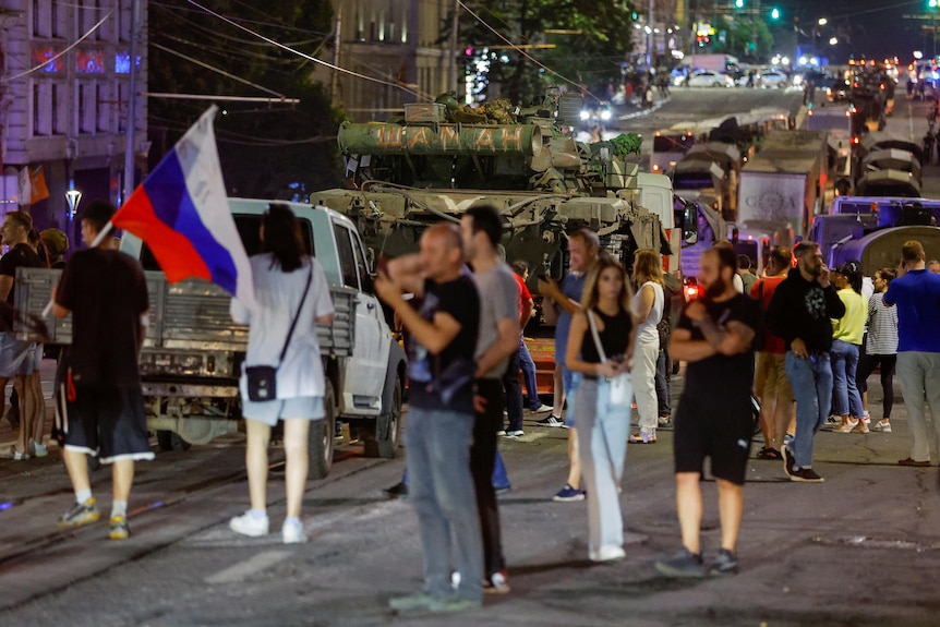 People on the streets wave and hold flags 