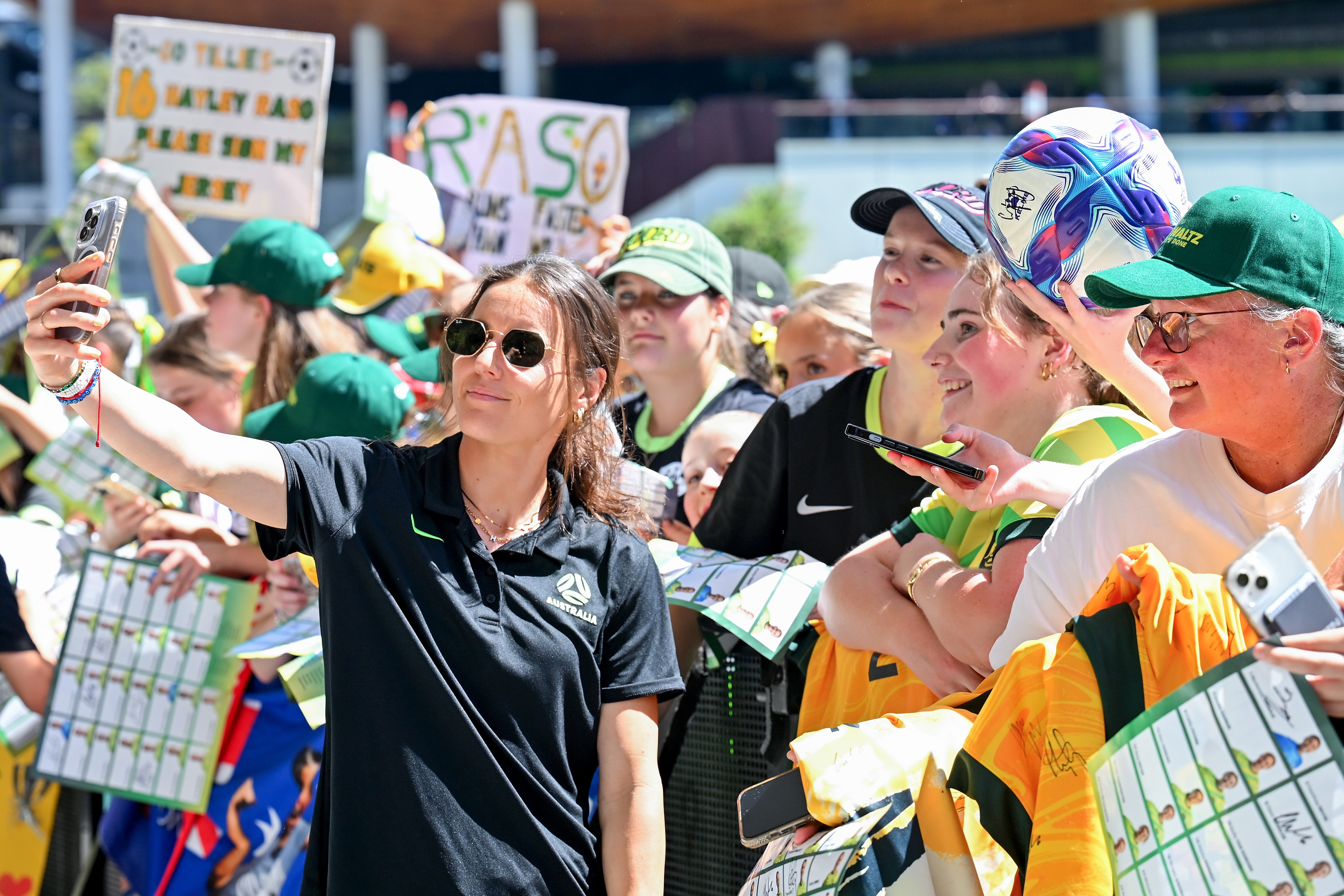 Matildas player Hayley Raso has a strained smile as she takes a selfie with fans