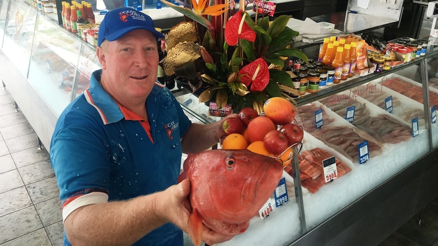 A bowl of fruit, flower arrangements and red reef fish are part of the Chinese cultural display at a seafood shop