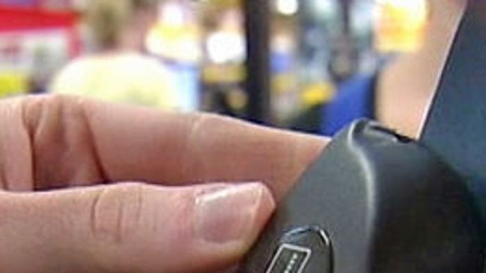 A person swipes a credit card through an EFTPOS machine