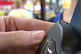 A person swipes a credit card through an EFTPOS machine