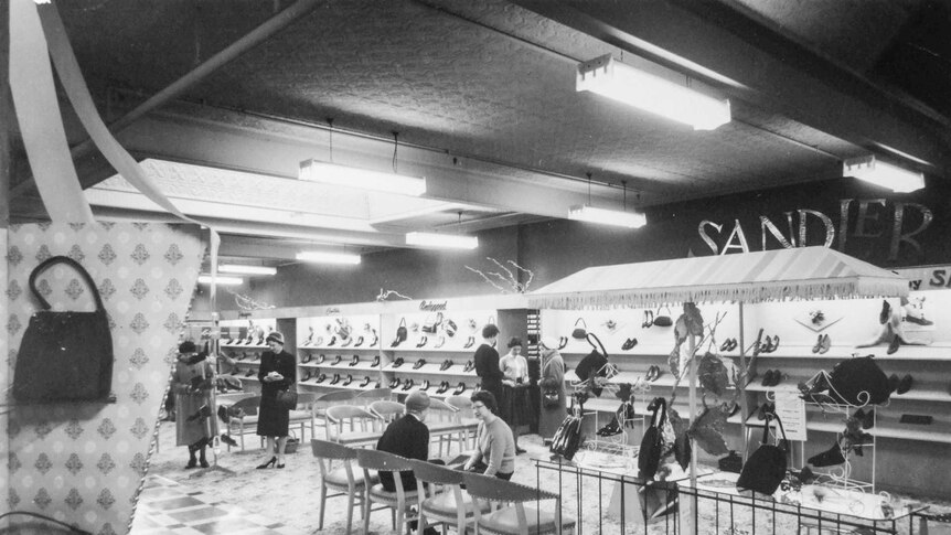 Black and white photograph of a shoe section at a department store in the 1960s with the sign Sandler on the wall