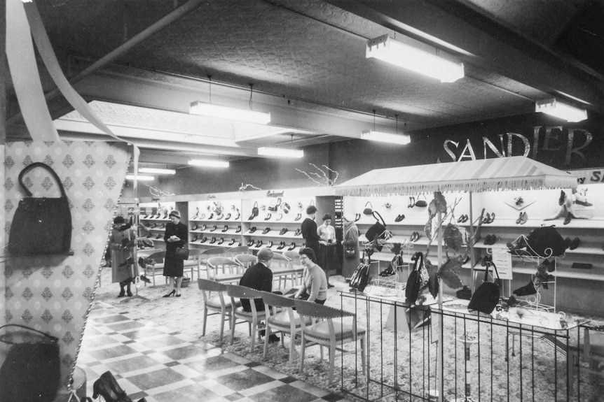 Black and white photograph of a shoe section at a department store in the 1960s with the sign Sandler on the wall