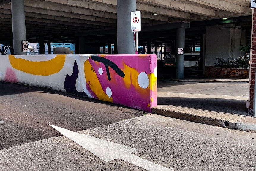 A bus interchange with street art on it.