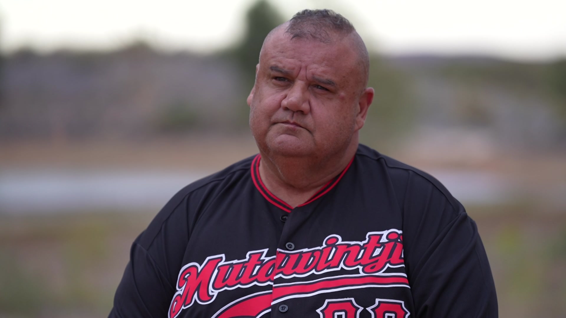 Un hombre con un mohawk mira a la cámara. 