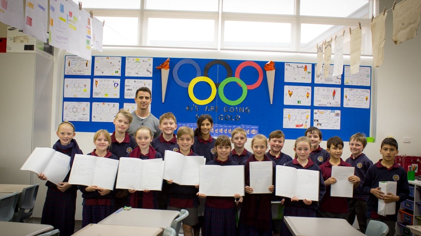 The 4/5 class at St Alberts Catholic School in Loxton stand in front of Olympic themed school work.