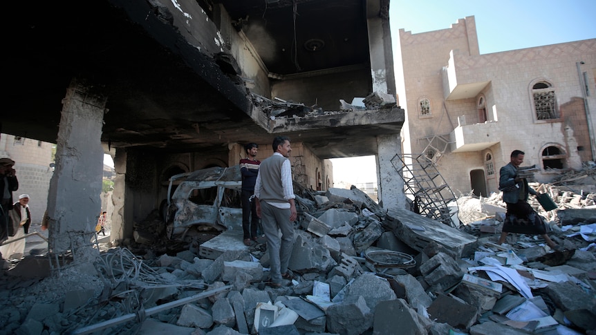 People inspect the wreckage of buildings that were damaged by air strikes.