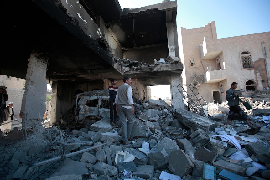 People inspect the wreckage of buildings that were damaged by air strikes.