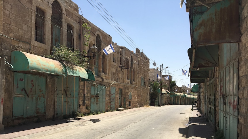 A deserted street with barricaded and rundown buildings in the heavily militarised 'H2' area of the West Bank.