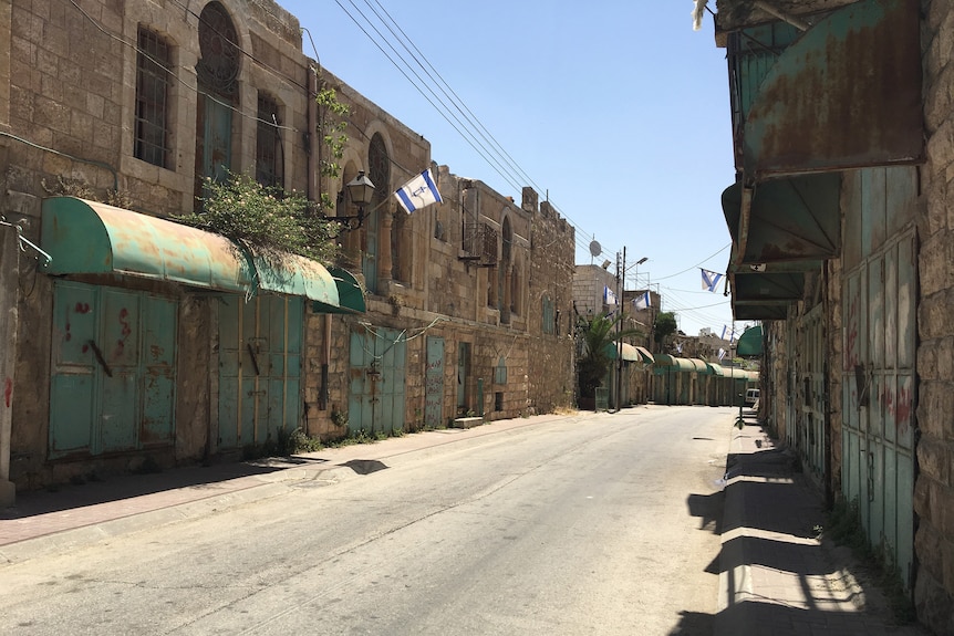 A deserted street with barricaded and rundown buildings in the heavily militarised 'H2' area of the West Bank.